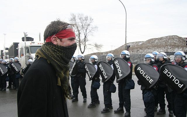 A protester facing off against police in Montreal in March. (illustrative photo: CC-BY Socialist Canada, Socialist Quebec, Flickr)