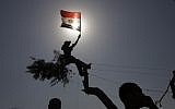 An Egyptian protester waves the national flag in Tahrir Square in Cairo (photo credit: Amr Nabil/AP)