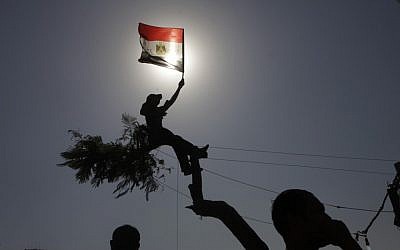 An Egyptian protester waves the national flag in Tahrir Square in Cairo (photo credit: Amr Nabil/AP)