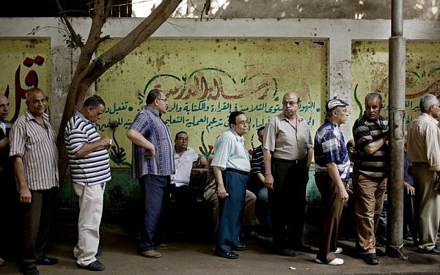 Egyptian men line up to vote at a polling station in Cairo on Sunday. (photo credit: Pete Muller/AP)