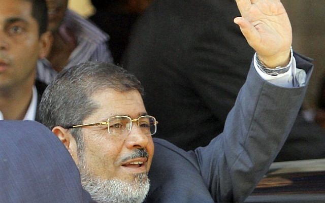 Egypt's President-elect Mohammed Morsi waves to his supporters following Friday prayers at Al-Azhar mosque in Cairo Friday (photo credit: Amr Nabil/AP)