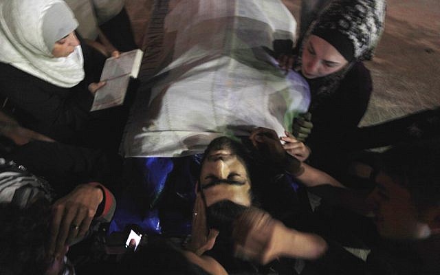 Relatives of Free Syrian Army soldier, Moayad Ghafir, who was killed during clashes with the regime gunmen, mourn over his dead body before his funeral in his family house on the outskirts of Idlib on Monday. (photo credit: AP)