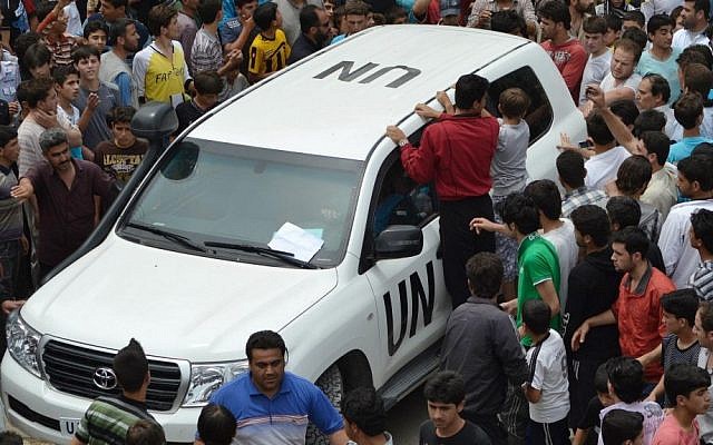 Syrians gather around a UN observers vehicle during a demonstration in northern Syria last week. (photo credit: Edlib News Network ENN/AP)