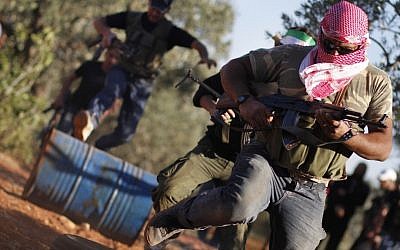 As the struggle to oust Syrian President Bashar Assad continues, Free Syrian Army members train with their weapons on the outskirts of Idlib, Syria, June 9 (photo credit: AP)