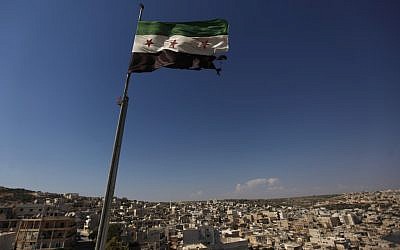 A Syrian revolutionary flag waves on top of a building on the outskirts of Aleppo, Syria, on Tuesday (photo credit:AP)