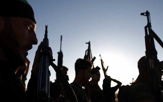 Free Syrian Army members raise their weapons during a training session on the outskirts of Idlib, Syria, Thursday, June 7, 2012 (photo credit: AP/Khalil Hamra) Free Syrian Army members raise their weapons during a training session on the outskirts of Idlib, Syria, Thursday, June 7, 2012 (photo credit: AP/Khalil Hamra)