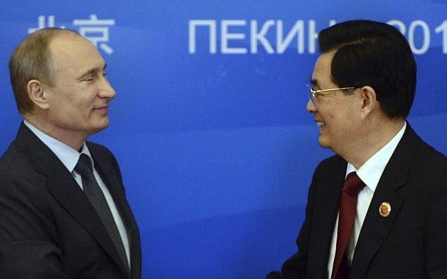 Russian President Vladimir Putin, left, shakes hands with Chinese President Hu Jintao during a signing ceremony at the Shanghai Cooperation Organization (SCO) summit at the Great Hall of the People in Beijing, China Thursday (photo credit: AP Photo/Mark Ralstonl)