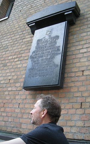 The author beneath the plaque at the site of the Borneplatz Synagogue (photo credit: K R Horovitz)