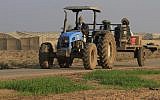 Illustrative: A farmer returns from work in the greenhouse of Kibbutz Nahal Oz, near the Israel-Gaza border. (Tsafrir Abayov/Flash90)