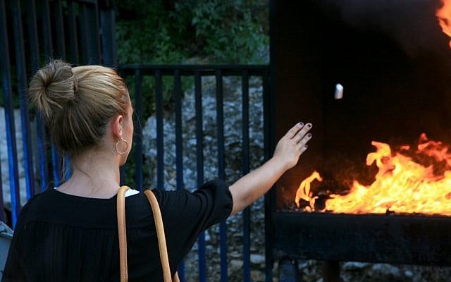 A young woman throws candles into the fire, a popular ritual at the burial site of Rabbi Yonatan ben Uziel (photo credit: Chen Leopold/Flash 90) A young woman throws candles into the fire, a popular ritual at the burial site of Rabbi Yonatan ben Uziel (photo credit: Chen Leopold/Flash 90)