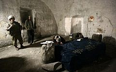 File: Jews at prayer in Joseph's Tomb in the West Bank city of Nablus as IDF soldiers stand guard. (Abir Sultan/Flash90)