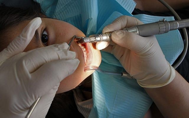 A young girl sits in the dentist chair. (Illustrative photo credit: Nati Shohat/FLASH90)