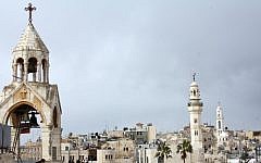 The Church of the Nativity (left) and the 19th-century mosque of Omar ibn al-Khattab looking over Manger Square in Bethlehem (photo credit: Najeh Hashlamoun/Flash90)