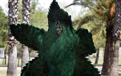 A man dresses as a marijuana leaf during a gathering in Tel Aviv's  Hayarkon Park to mark 'International Marijuana Day' on April 20. (photo credit: Tsafrir Abayov/Flash90)