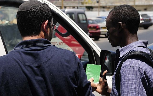 Immigration police check the papers of an African migrant in South Tel Aviv (photo credit: Tomer Neuberg/Flash90)