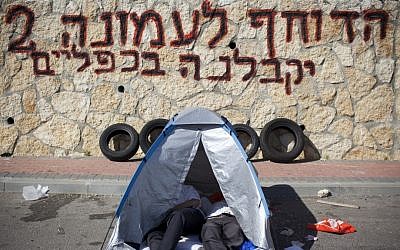 Graffiti warning of a second Amona, where dozens were injured in clashes, is sprayed above tires ready for burning (photo credit: Yonatan Sindel/Flash90)