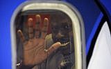 A South Sudanese man waves from inside an airplane at Ben Gurion airport (photo credit: Kobi Gideon/GPO/Flash90)