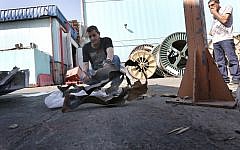 Men examine a rocket fired by Gaza terrorists that landed in Sderot's industrial zone in June (photo credit: Tsafrir Abayov/Flash90)