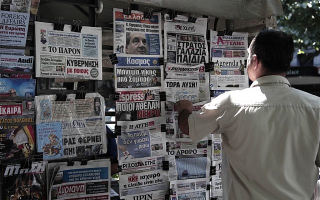 A Greek man looks at the front pages of newspapers on Saturday, the day before general elections. (photo credit: Dimitri Messinis/AP) A Greek man looks at the front pages of newspapers on Saturday, the day before general elections. (photo credit: Dimitri Messinis/AP)