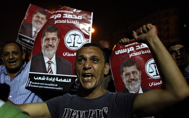 Egyptian Muslim Brotherhood supporters chant slogans and carry posters with a picture of presidential candidate, Mohammed Morsi and Arabic that reads "Mohammed Morsi, president for Egypt, revival is the will of the people," during an anti-ruling military council demonstration in Tahrir Square, Cairo, Egypt Wednesday. (photo credit: AP/Nasser Nasser)