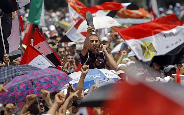An Egyptian supporter of the Muslim Brotherhood's candidate for president, Mohammed Morsi, raises his shoe in protest as he shouts slogans in Tahrir Square, Cairo, Egypt, Friday. (photo credit: AP/Amr Nabil) An Egyptian supporter of the Muslim Brotherhood's candidate for president, Mohammed Morsi, raises his shoe in protest as he shouts slogans in Tahrir Square, Cairo, Egypt, Friday. (photo credit: AP/Amr Nabil)