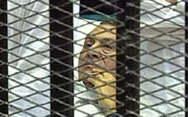 This August 3, 2011 image made from video by Egyptian State Television shows Hosni Mubarak, then 83, lying on a hospital bed inside a cage of mesh and iron bars in a Cairo courtroom. (photo credit: Egyptian State Television/AP)