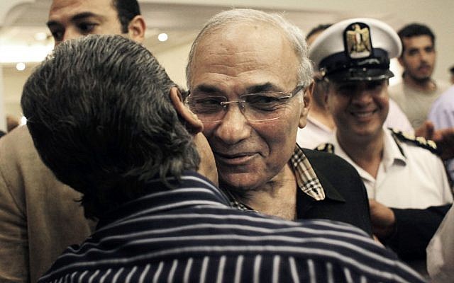 Egyptian presidential runoff candidate Ahmed Shafiq is greeted by a supporter after attending a press conference in Cairo, Egypt (photo credit: AP/Nasser Nasser)