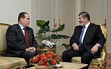 Mohammed Morsi meets caretaker Prime Minister Kamal el-Ganzouri Monday (photo credit: AP Photo/Middle East News Agency)