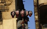 An Egyptian protester carries the image of Mubarak and his aides in a Cairo protest (photo credit: AP Photo/Nasser Nasser)