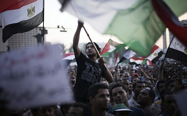 Egyptian protesters wave national flags and banners in Tahrir Square in Cairo on Thursday. (photo credit: Manu Brabo/AP)