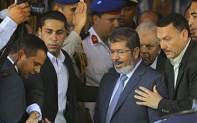 Egypt's President-elect Mohammed Morsi, center, is guarded by presidential security as he leaves Friday prayers at Al-Azhar mosque in Cairo Friday. Morsi was declared Egypt's first freely-elected president Sunday. (photo credit: Amr Nabil/AP)