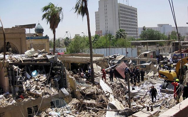 Firefighters and rescuers search for victims at the site of a bombing in Baghdad in June 2012. (photo credit: Hadi Mizban/AP)