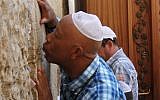 Hip hop mogul Russell Simmons kisses the stones of the Western Wall in Jerusalem's Old City, 2012 (photo credit: Blake Sobczak/AP)