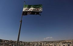 A Syrian revolutionary flag waves on top of a building on the outskirts of Aleppo. (photo credit: Khalil Hamra/AP)