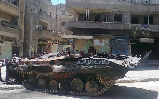A Syrian tank, with grafitti reading "Assad's dogs" in the town of Idlib on Monday. (photo credit: (AP/Edlib News Network ENN)