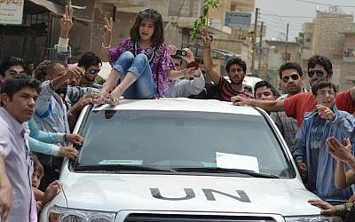 A Syrian girl sits atop a UN observers vehicle during a protest May 29 (photo credit: AP Photo/Edlib News Network ENN)