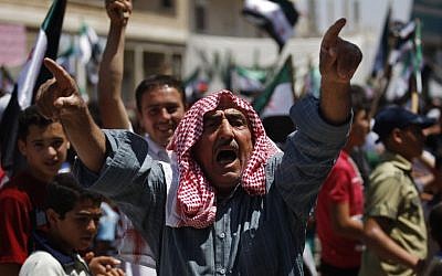 A Syrian man chants slogans during an anti-Bashar Assad protest after Friday prayers on the outskirts of Idlib, Syria. (AP)