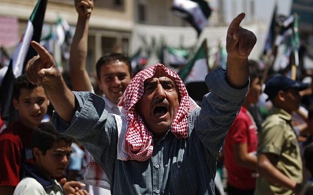 A Syrian man chants slogans during an anti-Bashar Assad protest after Friday prayers on the outskirts of Idlib, Syria. (AP)