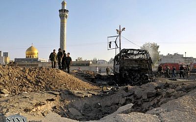 Syrian soldiers stand at the explosion site where a car bomb exploded near the shrine of Sayyida Zeinab, Thursday, June 14, 2012. (photo: AP/SANA)