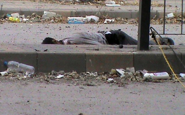 A body lying in the streets of Homs, June 21 (photo credit: AP/Shaam News Network, SNN)