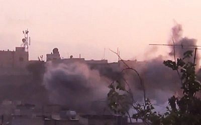 In this image made from amateur video released by the Shaam News Network smoke rises from buildings following purported shelling in Homs on June 26th 2012. (photo credit: AP/Shaam News Network)