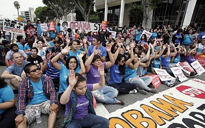 'Right to Dream' students and supporters block the street outside the federal Metropolitan Detention Center Friday in Los Angeles to celebrate the Obama administration's decision to stop deporting younger illegal immigrants (photo credit: AP/Nick Ut)
