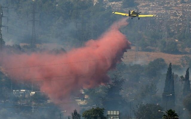 An airplane sprays flame retardant on a fire near Motza, on the outskirt of Jerusalem Tuesday (photo credit: Nati Shohat/Flash90)
