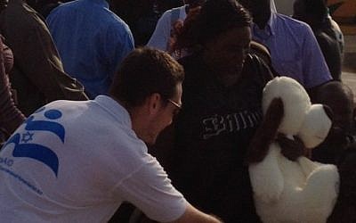 An IsrAID worker with African refugees (photo credit: courtesy)
