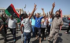 Libyans celebrate in Martyrs' Square in Tripoli after voting in the first democratic election in decades in July (photo credit: AP/Abdel Magid Al Fergany)