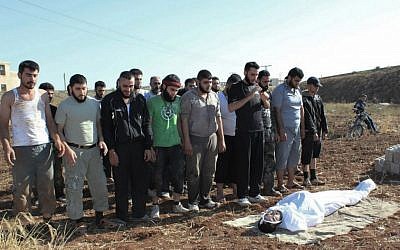 Syrians pray during the funeral procession of a man killed, in Homs, Syria, on Saturday, July 15 (photo credit: AP/Shaam News Network)