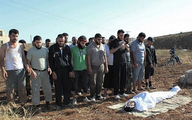 Syrians pray during the funeral procession of a man killed, in Homs, Syria, on Saturday, July 15 (photo credit: AP/Shaam News Network)