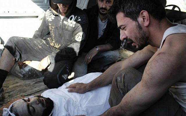 A Syrian man mourns his friend, killed Saturday in Homs (photo credit: AP Photo/Shaam News Network)