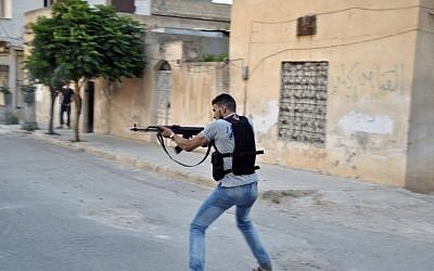 A Syrian rebel fires his weapon at Syrian troops in Idlib, Syria, July 22 (AP Photo/Fadi Zaidan)