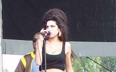 Amy Winehouse in concert, August 2007 (photo credit: CC BY-SA 3.0, by Massic80, Wikimedia Commons)